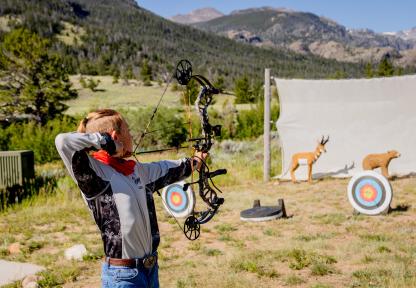 boy shooting archery at camp boy shooting archery at camp